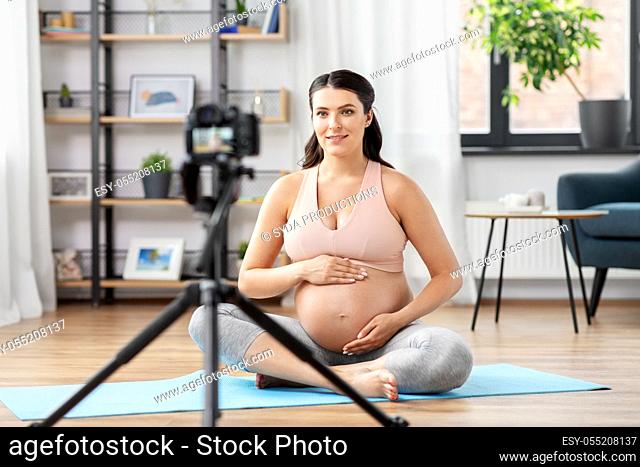 happy pregnant woman blogger recording yoga video