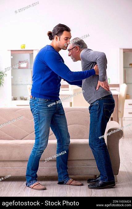 Young man looking after his sick father at home