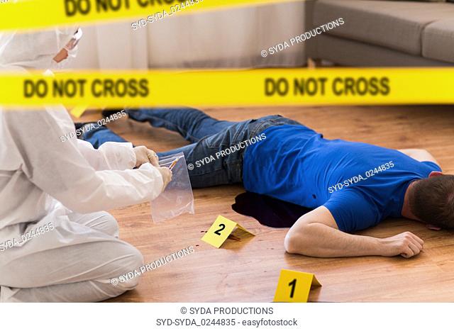 criminalist collecting evidence at crime scene