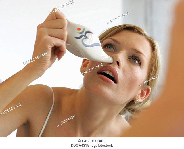 young adult woman makes nasal douche