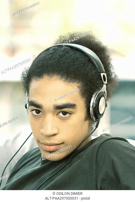 Young man listening to headphones, portrait
