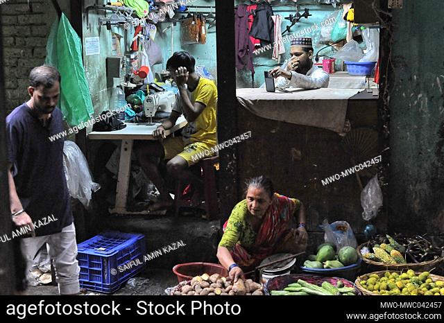 Life as a Bihari. Woman selling vegetables, with a tailor shop in the background. ‘Biharis’ refers to the approximately 300