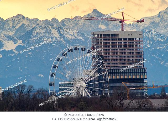 28 November 2019, Bavaria, Markt Indersdorf: The big wheel ""Hi-Sky München"" and a skyscraper under construction can be seen in foehn weather off the Alps more...
