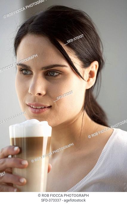 Young woman with a glass of latte macchiato