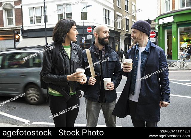 Group of friends on the streets of London talking over coffee