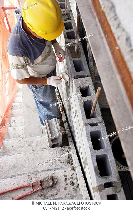 Construction/Mason worker building cement block wall
