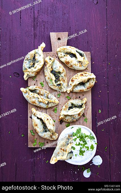 Mini pide (flatbread) with spinach filling and yogurt herb dip