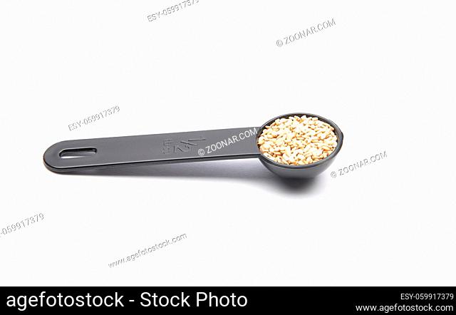 Sesam in Dosierlöffel auf weißem Hintergrund - Sesame in measuring spoon on white background