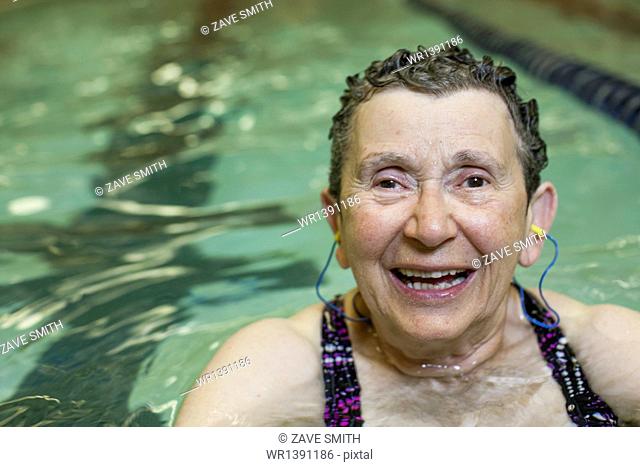 An elderly woman in a swimming pool, taking exercise