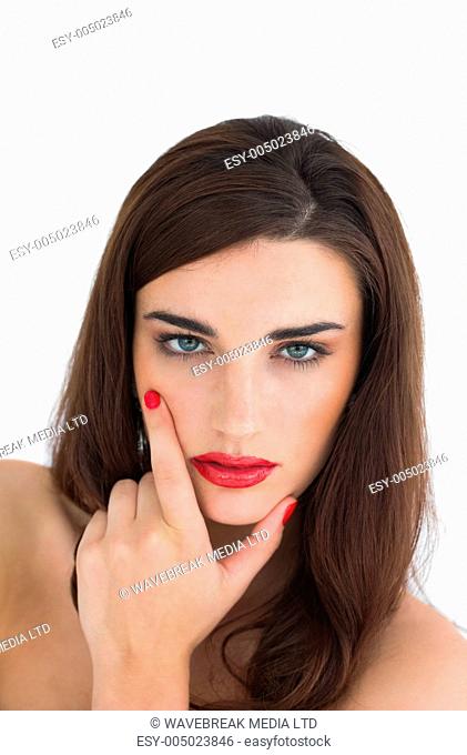 Woman with red lips looking at camera while touching chin