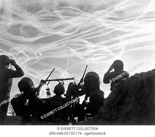 Christmas Day dogfights streaked the sky with vapor trails from Allied and German planes. Soldiers of an anti-aircraft battery watch the action over Puffendorf