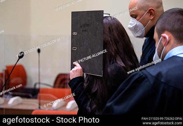 25 October 2021, Bavaria, Munich: The defendant Jennifer W. (l) is led into the courtroom before the trial begins. The woman from Lohne in Lower Saxony is...