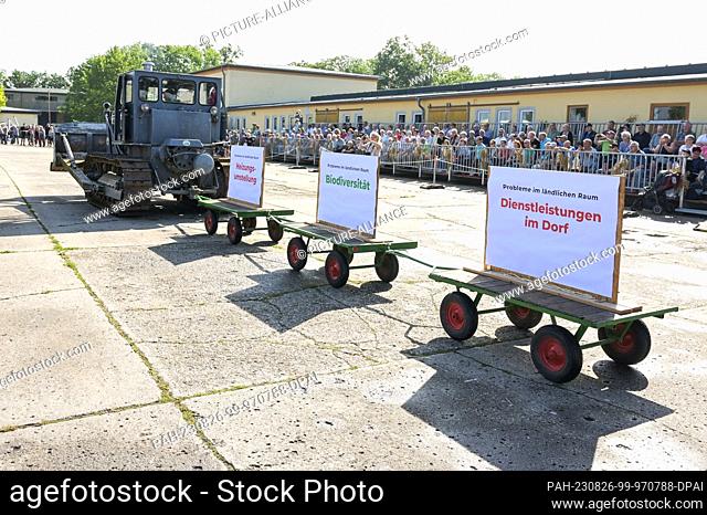 26 August 2023, Saxony-Anhalt, Bernburg: A 100-horsepower caterpillar pulls trailers with panels on rural issues off the grounds for the opening of the Historic...