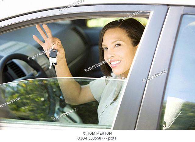 Woman sitting in car holding car keys
