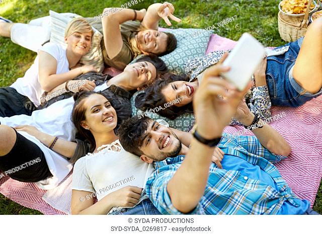 friends taking selfie on picnic at summer park