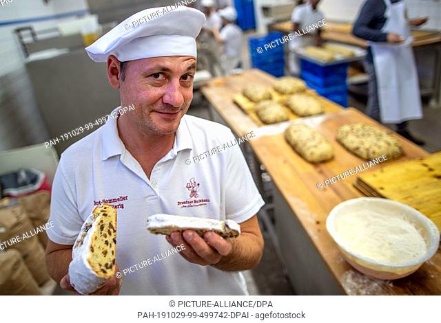 18 October 2019, Saxony, Dresden: Master baker and managing director Tino Gierig tries a freshly baked Christmas stollen in the Dresden bakery