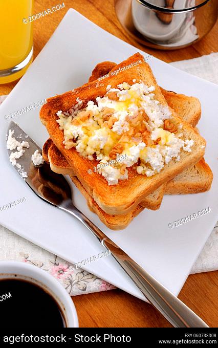 Crisp, fresh toast ricotta, honey and nuts for breakfast with orange juice