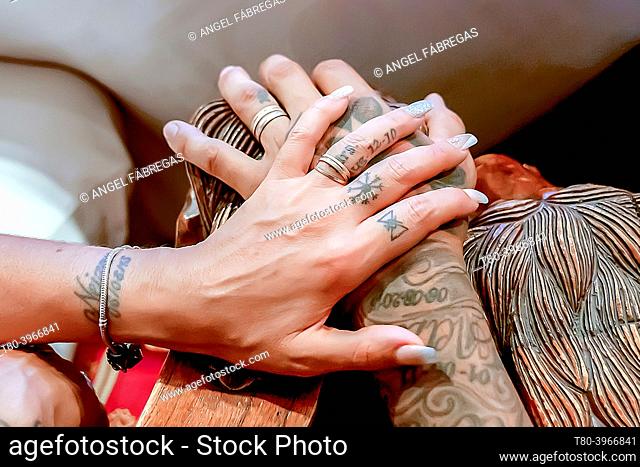 crossed hands with alliances and tattoos