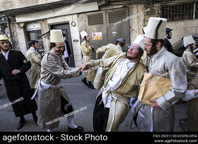 11 March 2020, Israel, Jerusalem: Ultra orthodox Jewish men in traditional attires take part in celebrations at Jerusalem's Mea She'arim neighbourhood to mark...