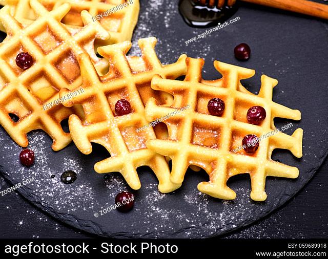 baked waffles on a black background, top view