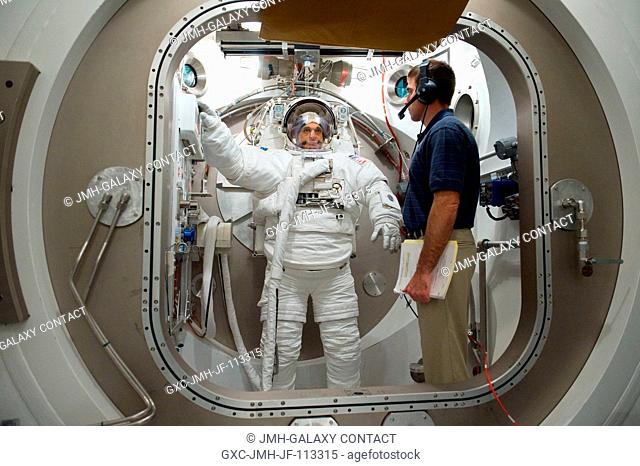 Astronaut Dave Wolf, STS-127 mission specialist, participates in an Extravehicular Mobility Unit (EMU) spacesuit fit check in the Space Station Airlock Test...