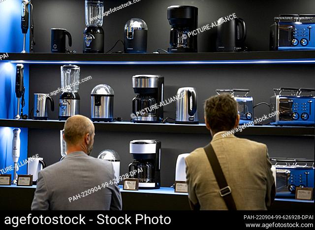 04 September 2022, Berlin: Two visitors look at home appliances at the Westinghouse stand at the IFA electronics fair. More than 1100 exhibitors show the...