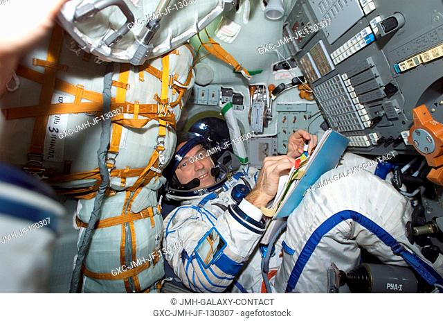 Astronaut Carl E. Walz, Expedition Four flight engineer, wearing a Russian Sokol suit, is seated in the Soyuz 3 spacecraft that is docked to the International...
