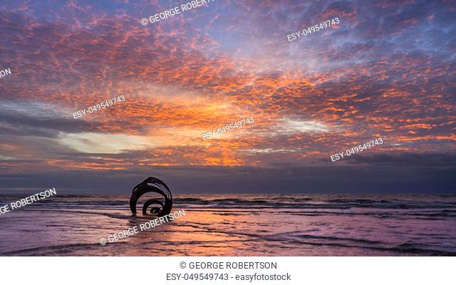 Sunset at the beach at Cleveleys on the Lancashire Coast with the artwork Mary's Shell in the foreground