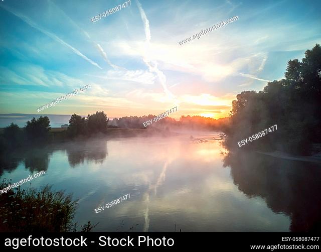 Sunrise over a small beautiful lake with fog over the water