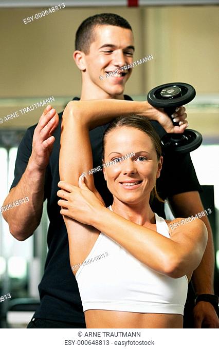 Trainer und Frau im Fitnessstudio