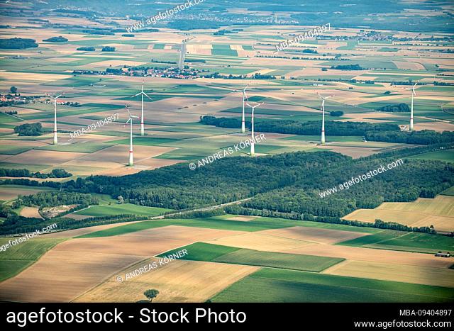 Aerial views of agricultural land, forest and villages with wind turbines