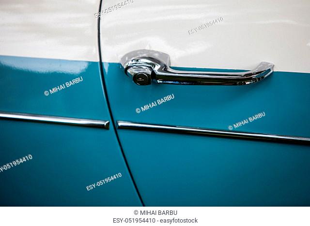 Close up shot of a vintage blue car door handle
