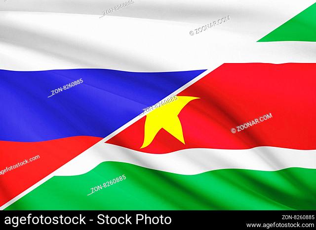 Flags of Russia and Republic of Suriname blowing in the wind. Part of a series