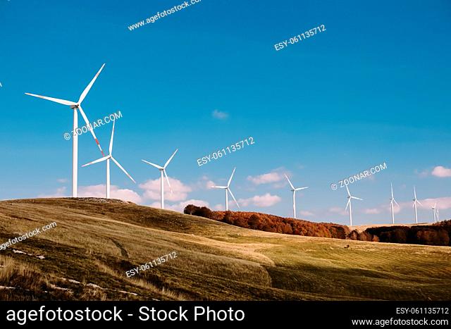 wind turbine farm. Wind power station with a group of wind turbines onshore in a beautiful scenery
