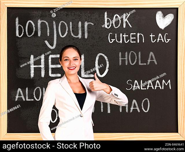 Woman near words hello in different languages on chalkboard