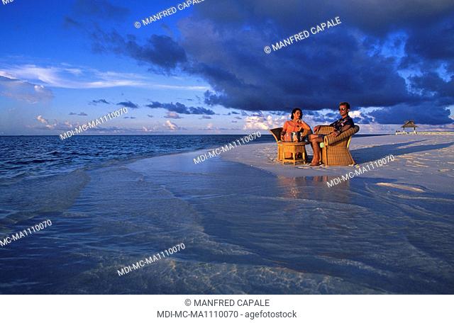 Couple assis sur une plage