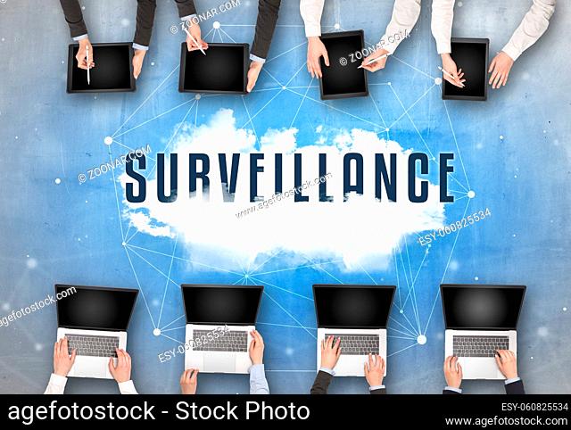 Group of people having a meeting with SURVEILLANCE insciption, web security concept