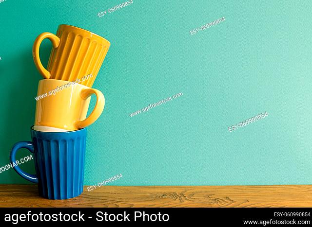 Stack of mug cup on wooden table. mint wall background. copy space