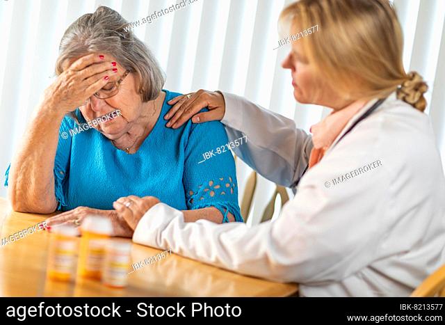 Female doctor consoling distraught senior adult woman