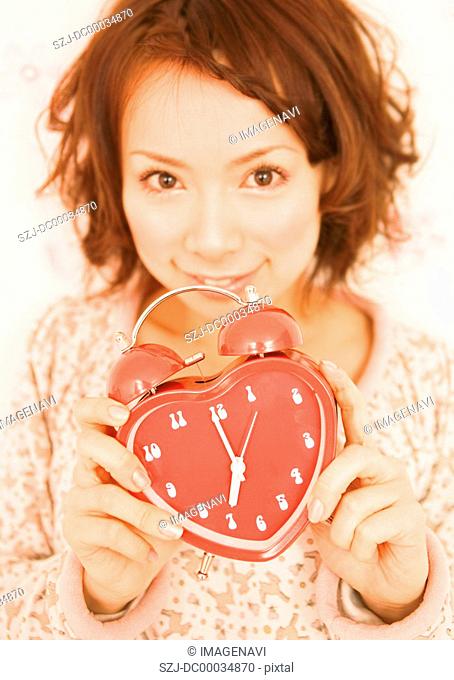 A woman holding alarm clock