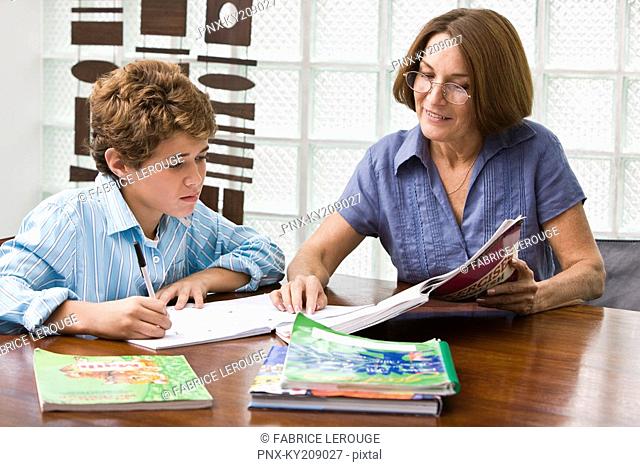 Woman helping her grandson in homework