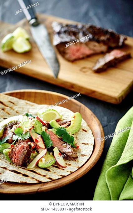 Tortillas with avocado salad and grilled beef steak
