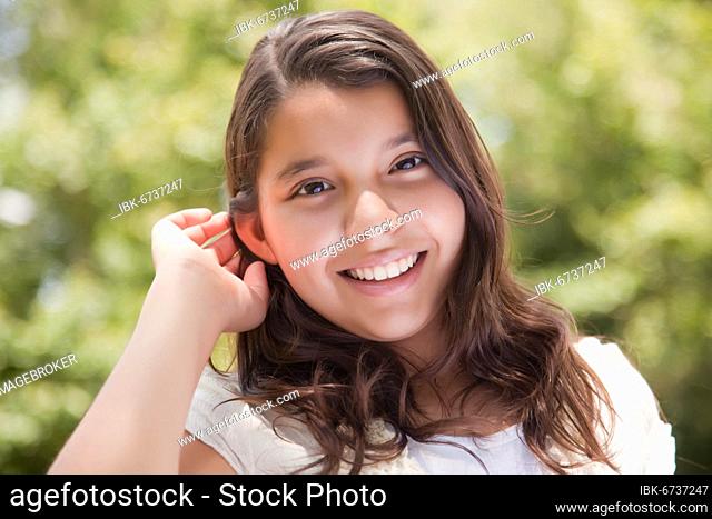Cute happy hispanic girl portrait in the park