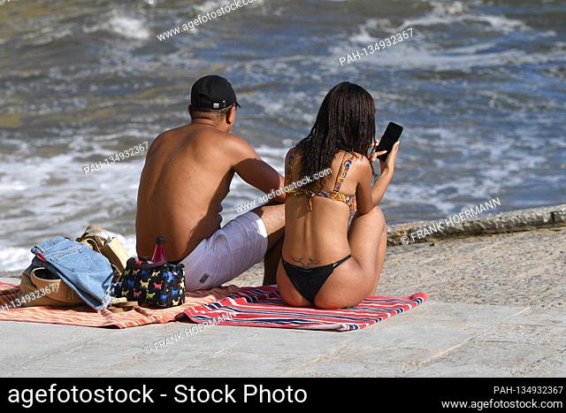 Little going on on Tamariz Beach in Estoril on 08/21/2020. A couple man and woman in bikini sit on their beach towels and sunbathe, sunbathing