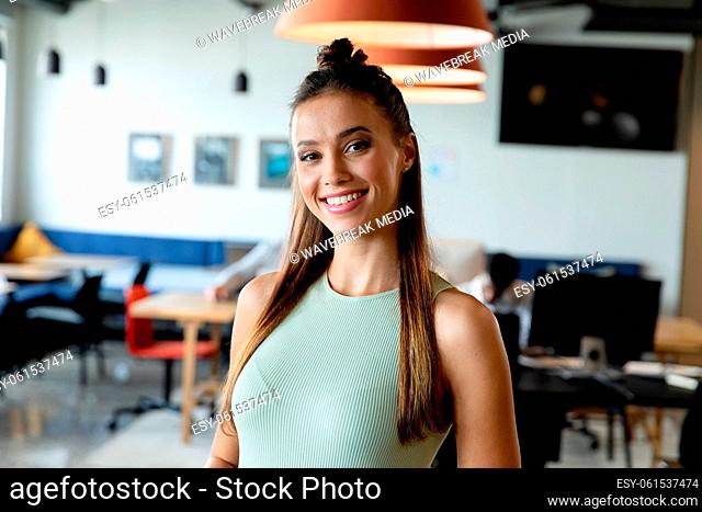 Portrait of smiling young caucasian businesswoman in creative office
