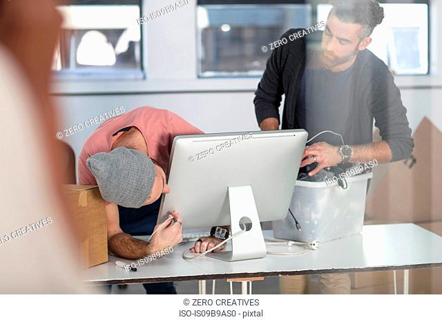 Colleagues in office connecting computer