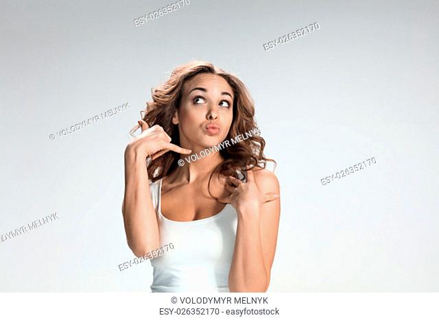 The young woman&#39;s portrait with different happy emotions on gray background. concept of communication by mobile phone
