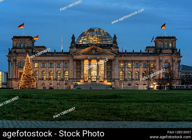 December 28, 2020, the Berlin Reichstag building by master builder Paul Wallot on Platz der Republik with flags and Weihaftertsbaum