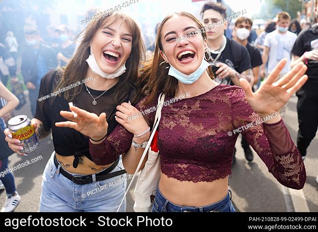 28 August 2021, Berlin: Young girls wear their medical masks under their chins during the techno demonstration ""Train of Love""