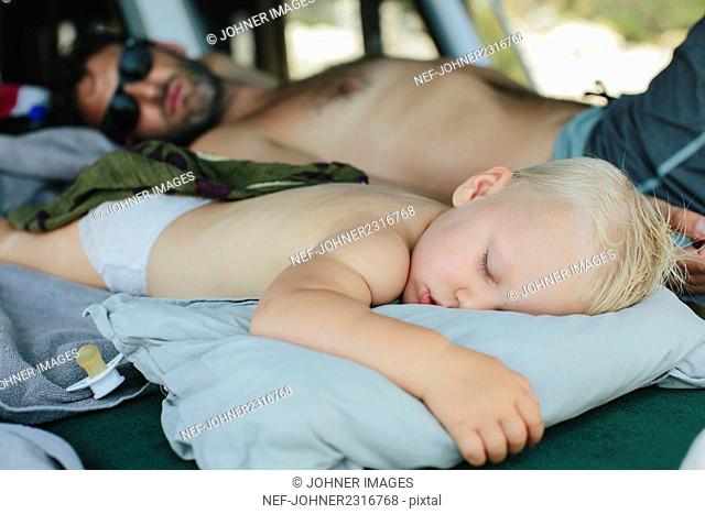 Father and son sleeping outdoors